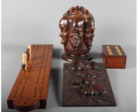 A 19th Century wooden tea caddy decorated gargoyle heads, two cribbage boards and a carved wooden panel