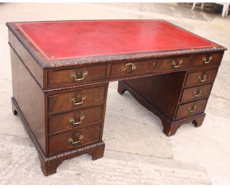 A Chippendale design mahogany twin pedestal desk, fitted red tooled leather top and nine drawers, carved egg and dart mouldin