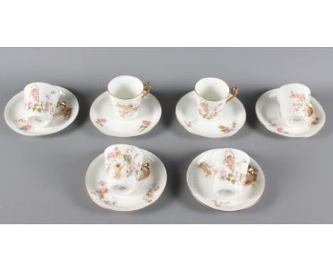 Seven Limoges porcelain coffee cans decorated cherubs and six matching saucers