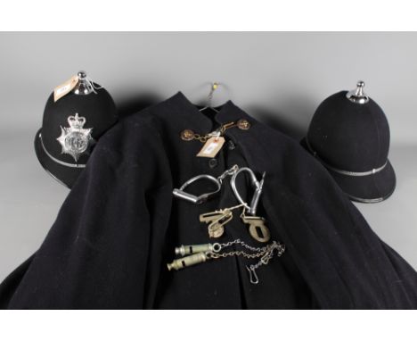 A policemens' cloak, a jacket, two helmets and a pair of handcuffs