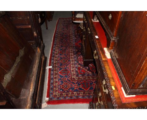 A Turkey carpet decorated central blue medallion and two subsidiary medallions on a red ground with five border stripes, 140"