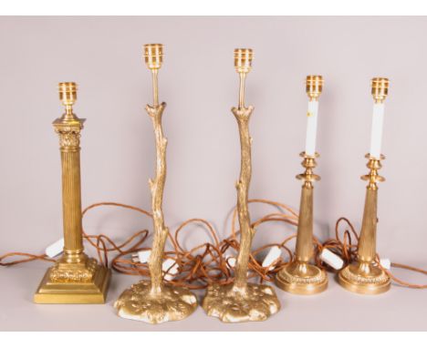 A brass Corinthian column table lamp, a pair of branch style brass lamps and another pair of brass lamps with circular bases