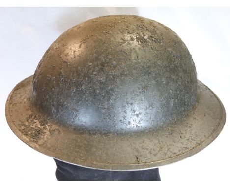 British WWI relic Brodie helmet with partial indistinct decal (possibly the Machine Gun Corps), retaining partial liner, dama