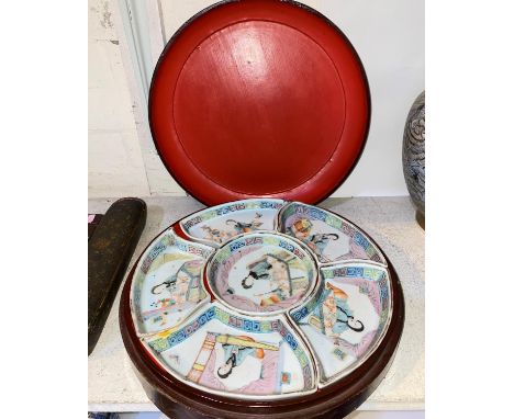 A Chinese hors d'oeuvres set with circular lacquer box containing, six ceramic dishes forming a circle decorated with slightl