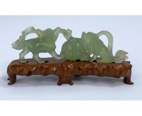 A Chinese jade coloured hardstone carved group of animals with a ball on carved wooden stand, Length 19cm.&nbsp;&nbsp;In good