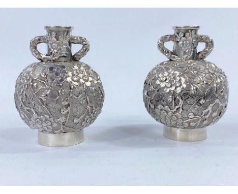 A Chinese pair of silver export vases of small spherical form with twin handles and all over relief decoration, height 6.5 cm