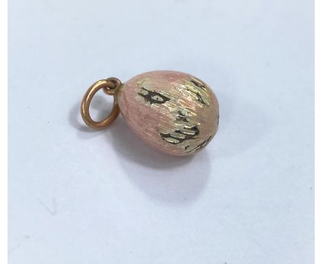 A small pink enamelled Russian style egg pendant / charm in the Faberge manner, stamped to loop A W, (loss to enamel) 