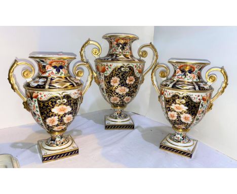 A 19th century Crown Derby garniture of 3 classical urn shaped vases with twin handles and pedestal bases, decorated in the I