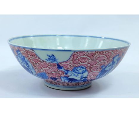 A Chinese ceramic bowl with blue and white figures of sages etc, with detailed red wave decoration to the exterior and interi