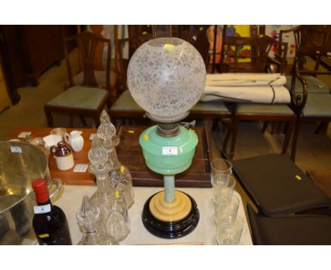 An Art Deco oil lamp with etched glass shade