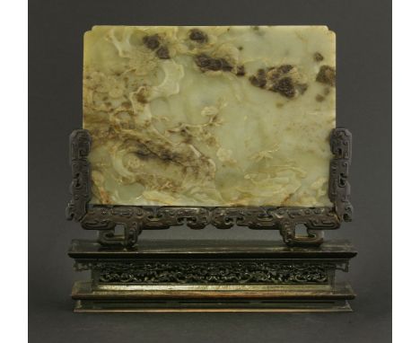 A Chinese jade plaque,19th century, the green rectangular stone flecked in brown and black, carved in low relief with pine, p