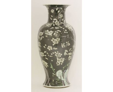 A famille noire vase, late 19th century, painted with blossoming prunus trees beside rocks, against a black ground, six chara