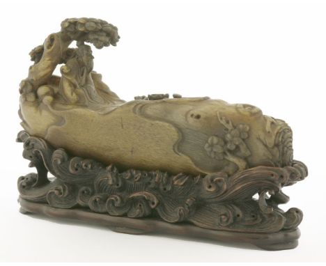 A Chinese rhinoceros horn carving,  early 20th century, of a literatus seated under a tree with a ruyi sceptre in his arms, a