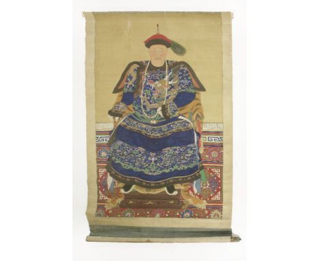 A large ancestor portrait painting,19th century, of an elderly man in blue dragon robes seated in a tixi lacquered armchair c