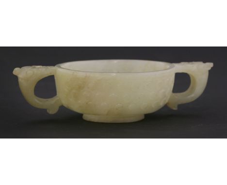 A celadon jade two-handled cup,Ming dynasty (1368-1644), with animal head handles and sides carved with studding, the cloudy 