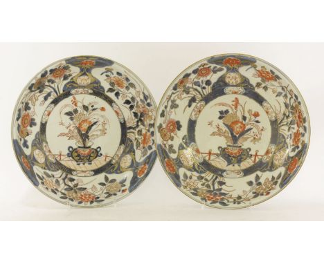 A pair of Japanese Imari plates,early 18th century, decorated in shades of midnight-blue, the centre painted with flowers in 