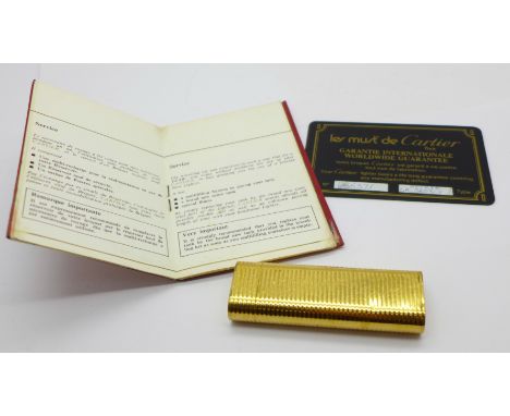 A Cartier lighter with guarantee and service booklet