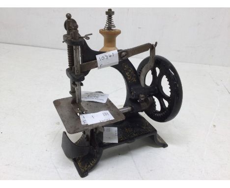 A miniature cast early 20th Century children's sewing machine, no makers name present, with miniature bobbin