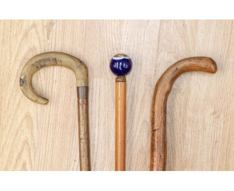 A collection of three walking sticks including horn and ceramic handles