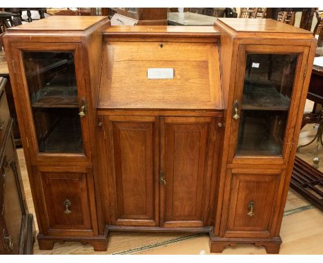 An early 20th Century treasurer/secretary's desk, in oak, comprising a central desk section and side compartments, two with b