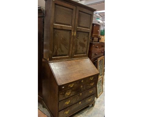 A late Georgian bureau bookcase in oak, two doors above four drawers, on bracket feet