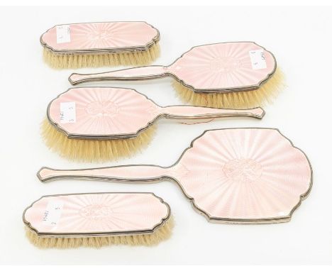 An Art Deco five piece silver mounted and pink enamel dressing table set comprising mirror, two hair and two clothes brushes,