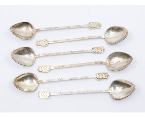 A set of six Continental low grade silver planished teaspoons with chevron / arrow head decoration to terminals, and engraved