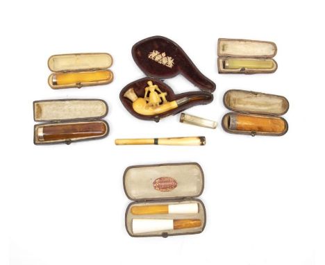 A collection of amber, gold and ivory cased cigarette holders, mostly with 9ct gold sleeves along with amber and silver pipe