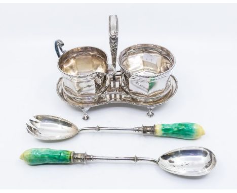 A silver plated sugar bowl and milk jug on stand along with plated salad servers, with green ceramic handles