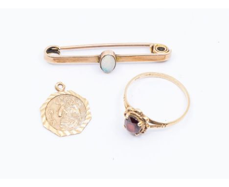 A 9ct bar brooch set with an oval opal, a 9ct gold St Christopher pendant and a 9ct gold  and garnet set ring, size P, combin