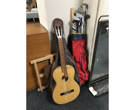 A golf bag containing a set of Dunlop irons and a driver, a dart board, a wooden easel and an acoustic guitar in carry bag 