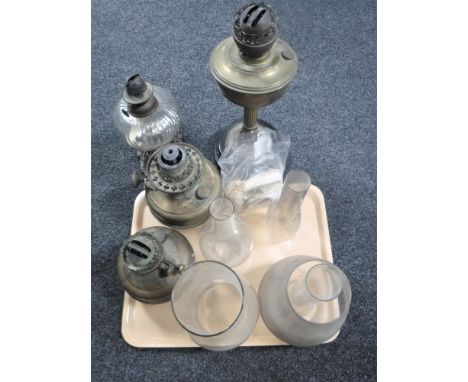 A tray of four vintage oil lamps, four glass chimneys, one shade and a bag of oil lamp wicks 
