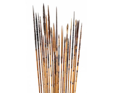 P.N. Guinea, a bundle of bamboo arrows and three wooden bows; The arrows with fine engraving, carved bamboo-wooden arrow ends