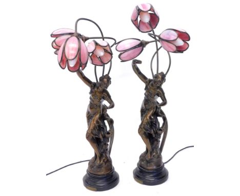 A pair of late 20thC French bronzed resin lamp bases, each with stained glass tulip shaped shades, 70cm H.