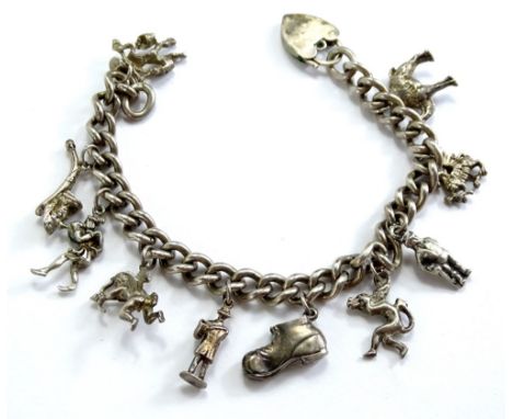 A silver charm bracelet, with various silver and silver plated charms, to include camel, dragon, man, shoe, cherub, pipe etc.