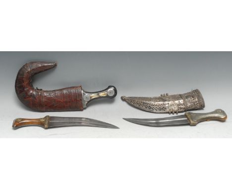 An Middle Eastern jambiya, 21cm curved blade with central ridge, the horn hilt steel-clad to verso and applied with brass rou