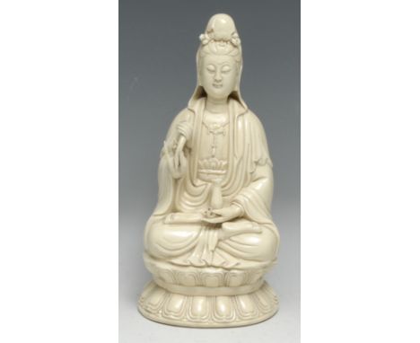 A Chinese Blanc de Chine figure, of Guanyin, seated in a lotus, glazed in an ivory tone, 26cm high, two impressed marks to ve