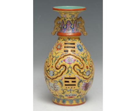 A Chinese ovoid reticulated puzzle vase, painted in polychrome enamels with flowers on a yellow ground, gilt scroll handles t