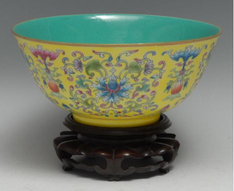 A Chinese circular bowl, brightly painted in polychrome enamels with lotus scrolls and precious objects on a yellow ground, t