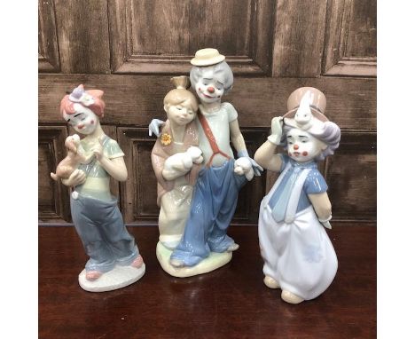 LLADRO CLOWN FIGURE GROUP, of a clown and a girl, both with poodle, 22cm high, along with two Lladro child clown figures (3)