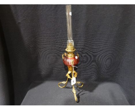 A Metal Based Oil Lamp With Cut Cranberry Tinted Reservoir