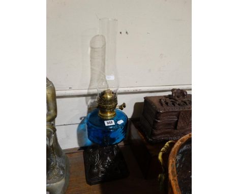 A Metallic Based Oil Lamp With Blue Tinted Reservoir