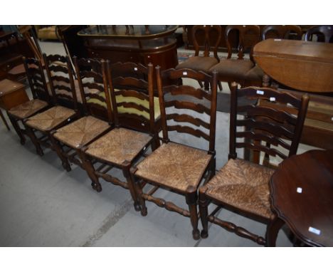 A harlequin set of six rush seated ladder back chairs