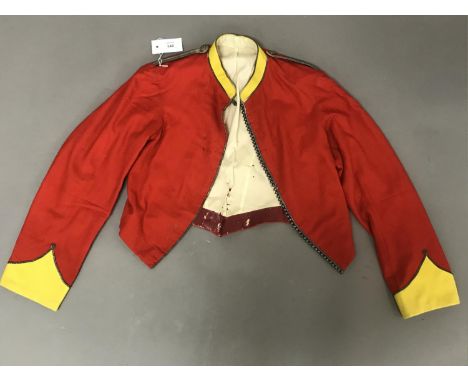 AN ARGYLL HIGHLAND RIFLES MESS JACKET. The red jacket with yellow cuffs and collar with beaded open front, the epaulettes of 
