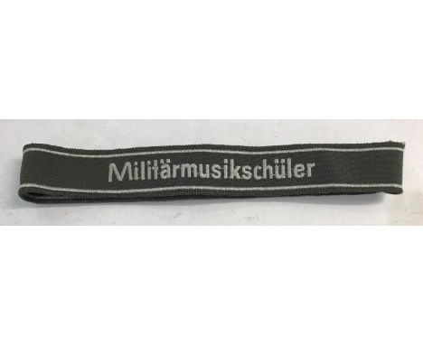 A GERMAN MILITARY CUFF TITLE. A Cuff Title 'Militarmusikschuler' in white against a brown ground, 28mm. This item is Second W