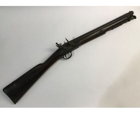 AN EARLY 19TH CENTURY FLINTLOCK RIFLE. With a 39.7cm steel barrel with swivalling ram rod and flintlock action with sliding s