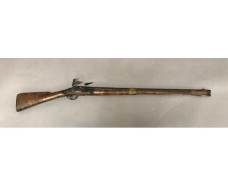 A 19TH CENTURY FLINTLOCK RIFLE. The 86.5cm large bore barrel with flintlock firing action, apparently unmarked, the barrel wi