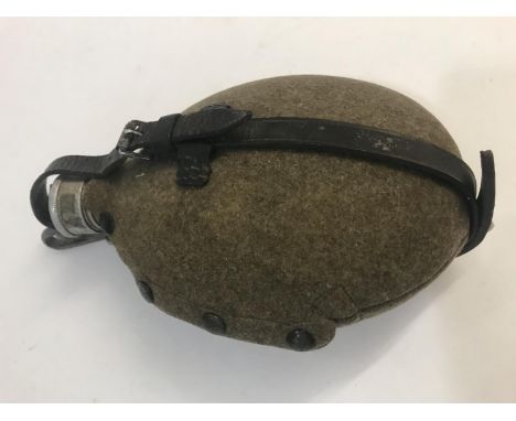A GERMAN ARMY WATER BOTTLE. A second World War German army aluminium water bottle with felt cover with fastening studs and a 