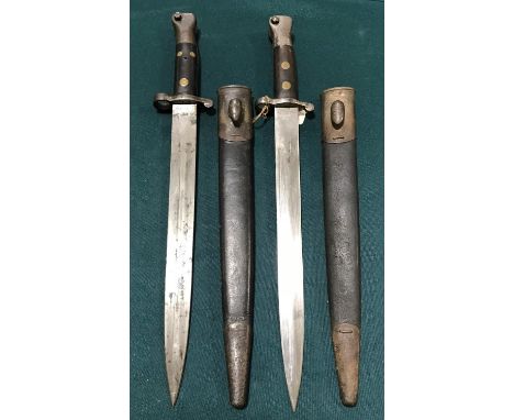 TWO 1888 PATTERN BAYONETS AND SCABBARDS. An 1888 Pattern bayonet with a 30.5cm double edged blade with various stamped marks 