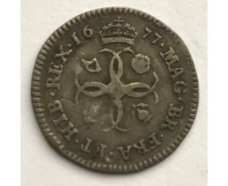 A CHARLES II FOURPENCE. A Charles II Fourpence dated 1677, draped laureate bust r, four conjoined Cs to the reverse. 